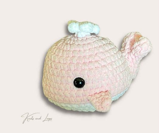 Pastel-colored plush whale toy on a light background